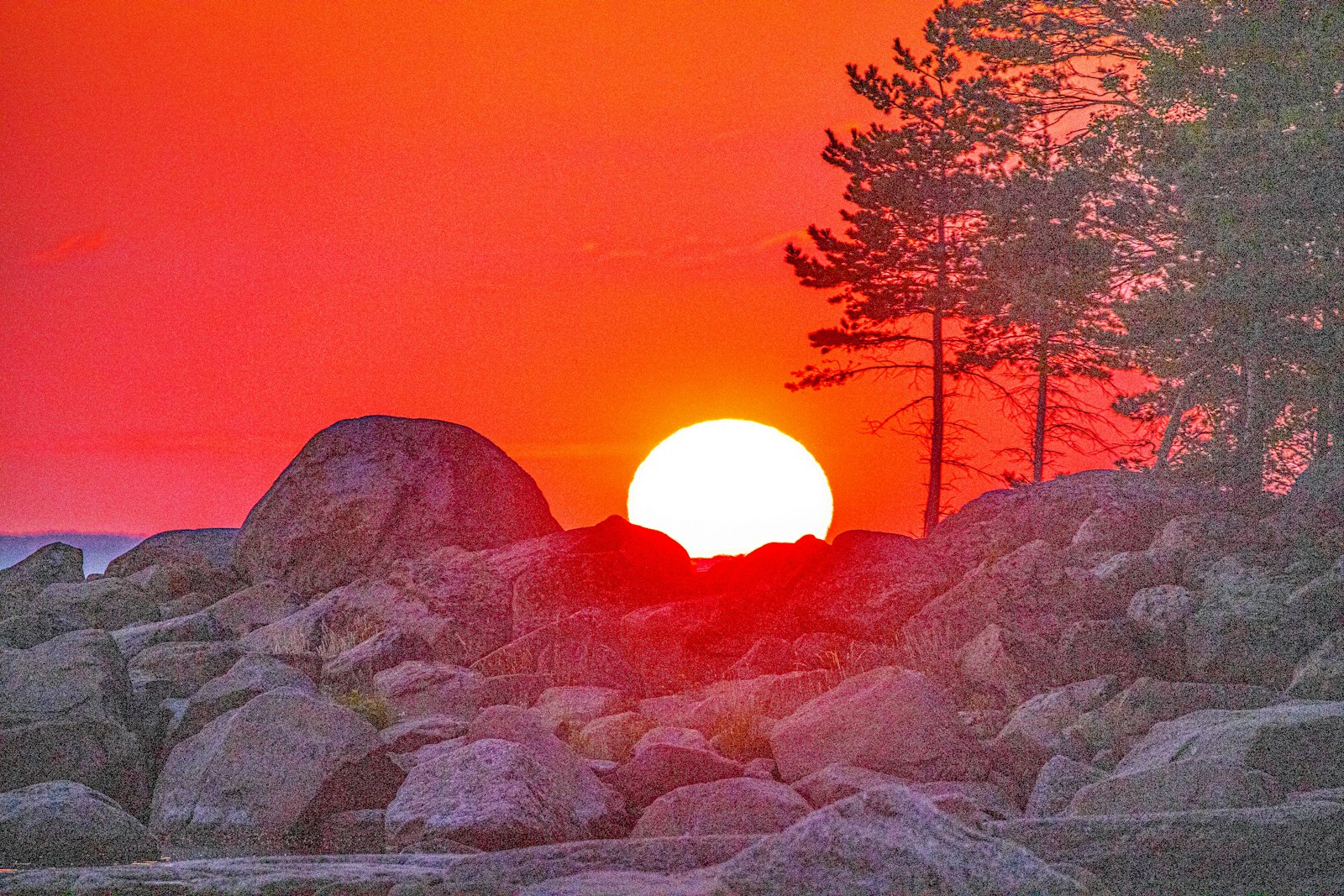 Solnedgång över klippor vid havet